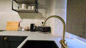 een aanrecht met een wastafel en een kraan bij The Maisonette central Buxton in Buxton +13 foto's