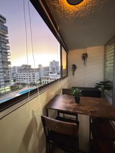 a table and chairs in a room with a large window at Son de Metro Apartment - Condado Beach & Pool, Walk to Ocean in San Juan