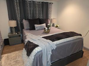 a bedroom with a large bed with two lamps at Private Garden Suite in Bayshore in Bay Shore