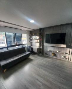 een woonkamer met een bank en een flatscreen-tv bij Hotel Atheron suite La Magia de Zipaquirá in Zipaquirá