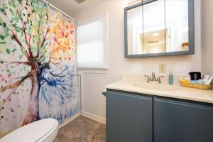 een badkamer met een boomschilderij op het douchegordijn bij Quiet Retreat - Piano Firepit Peloton in Pittsboro +25 foto's