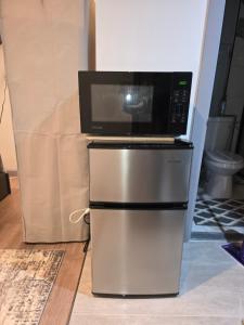 a microwave sitting on top of a refrigerator at Private Garden Suite in Bayshore in Bay Shore