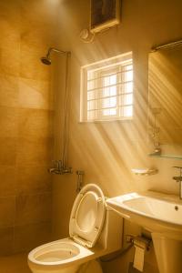 ein Badezimmer mit Toilette und Waschbecken und einem Fenster in der Unterkunft The Atelier G-13 in Islamabad