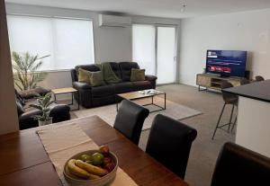 a living room with a table with a bowl of fruit at Apartment 303 Tauranga in Tauranga