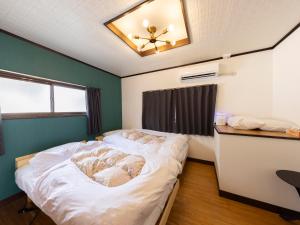 a bedroom with two beds and a ceiling fan at 貸切宿ひととき in Numazu
