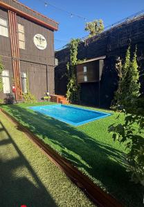 een zwembad in een tuin naast een gebouw bij Casa Withe opción jacuzzi in Villa Alemana