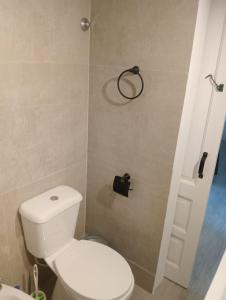ein Badezimmer mit Toilette und einem Kleiderbügel an der Wand in der Unterkunft Mansilla playa in Mar del Plata