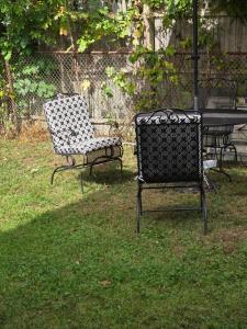two chairs sitting in the grass next to a table at Private Garden Suite in Bayshore in Bay Shore