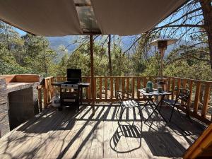 een terras met een grill en een tafel en stoelen bij Glamping MORET Tiny House M1 in Los Lirios +17 foto's