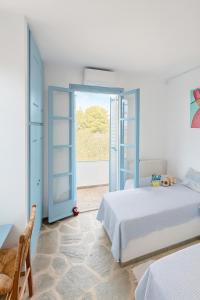 a bedroom with a bed and an open door at Villa Loretta with pool, jacuzzi and garden in Posidhonía