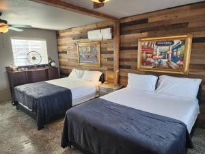 twee bedden in een kamer met houten wanden bij Sunrise Springs in Pahrump