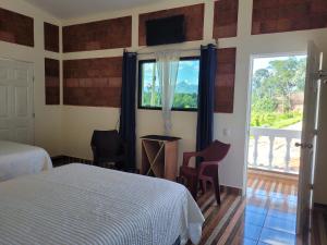 a bedroom with a bed and a window and a balcony at Luxury Posada inn in Los Amates