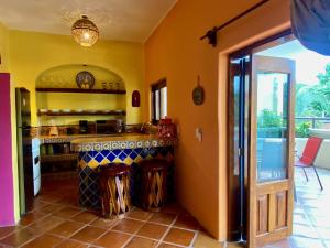 a kitchen with yellow walls and a counter top at Sol - Casa MoJo's charming 1BR, kitchen, pool in Sayulita