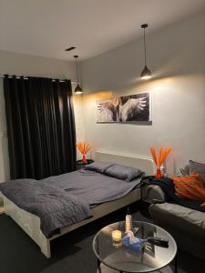 een slaapkamer met 2 bedden en een bank en een tafel bij استديو بطابع هادي in Al Khobar