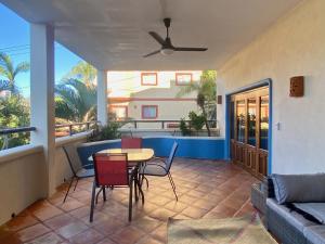 a patio with a table and chairs and a couch at Sol - Casa MoJo's charming 1BR, kitchen, pool in Sayulita