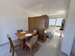 een eetkamer met een houten tafel en stoelen bij Loft novo e bem localizado in Biguaçu