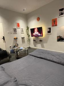 een slaapkamer met een bed en een flatscreen-tv aan de muur bij استديو بطابع هادي in Al Khobar