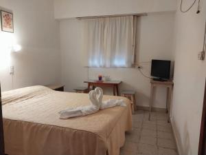 een slaapkamer met een bed met een handdoek erop bij Florencia Apartamentos y habitaciones in Necochea