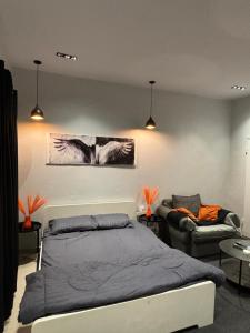 een slaapkamer met een bed en een bank bij استديو بطابع هادي in Al Khobar +5 foto's