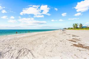 a beach with people swimming in the ocean at Starfish Sands - 580 in Longboat Key