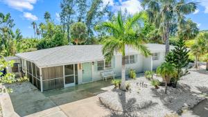 a house with palm trees in front of it at Starfish Sands - 580 in Longboat Key +52 photos