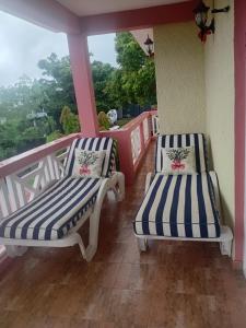 2 stoelen op een balkon met uitzicht bij Shantee Residence in Trou dʼ Eau Douce
