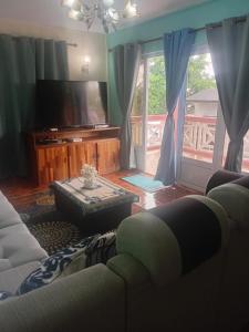 een woonkamer met een bank en een tv bij Shantee Residence in Trou dʼ Eau Douce