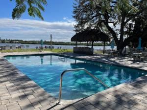 a swimming pool with blue water next to a lake at 2BR Renovated Siesta Key Condo, beach and pool access in Sarasota