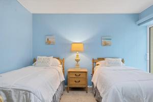 two beds in a room with blue walls at 2BR Renovated Siesta Key Condo, beach and pool access in Sarasota +25 photos