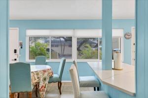 a dining room with blue walls and a table and chairs at 2BR Renovated Siesta Key Condo, beach and pool access in Sarasota