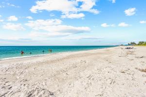 einen Strand mit Menschen, die im Meer schwimmen in der Unterkunft Starfish Shore - 578 in Longboat Key