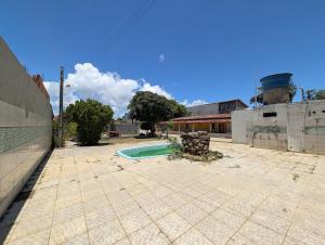 un cortile vuoto con piscina in un edificio di Casa Temporada Refúgio das Ondas a Guriri