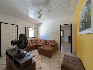 un soggiorno con divano e ventilatore di Casa Temporada Refúgio das Ondas a Guriri