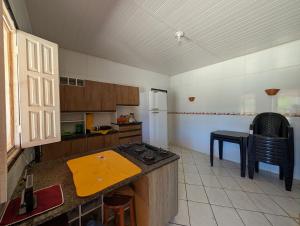 una cucina con un bancone e un tavolo di Casa Temporada Refúgio das Ondas a Guriri