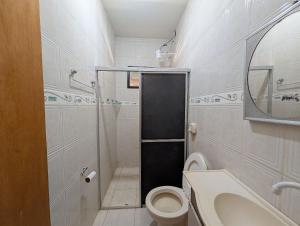 un piccolo bagno con servizi igienici e specchio di Casa Temporada Refúgio das Ondas a Guriri Altre 6 foto