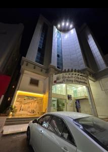 een auto die 's nachts voor een gebouw geparkeerd staat bij نزل Rest in Hail