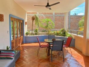 a patio with a table and chairs and a couch at Luna - Casa MoJo's delightful 1BR, kitchen, pool in Sayulita +3 photos
