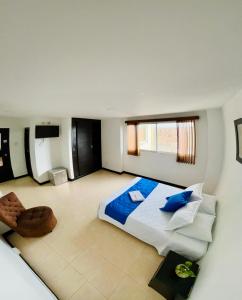 a bedroom with a large bed with blue pillows at Hotel Cristal Plaza in Popayan