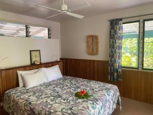 a bedroom with a bed with a flower on it at The Pointe Taveuni in Matei