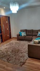 un soggiorno con un divano e un tappeto di Casa da Familia a Paulínia