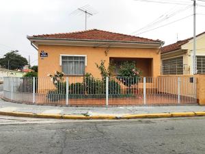 una casa gialla con una recinzione davanti di Casa da Familia a Paulínia