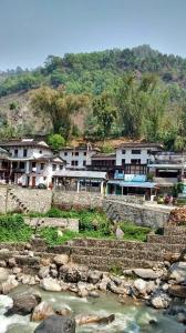 een groep gebouwen op een heuvel naast een rivier bij Hotel evergreen lodge in Kāskī