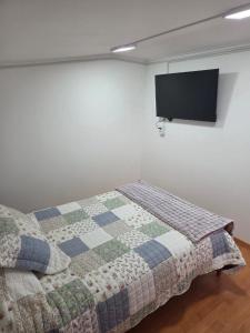 een slaapkamer met een bed en een tv aan de muur bij Cabaña Full Equipada Sector Norte B2 