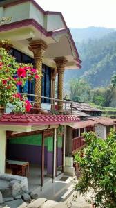 een gebouw met een balkon met bloemen erop bij Hotel evergreen lodge in Kāskī