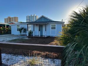 a blue house with a fence in front of it at Beachside Bliss - Breakfast, Walk to Schooners, Sleeps 15, Fenced Privacy in Panama City Beach