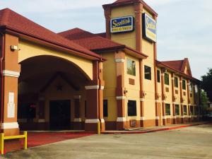ヒューストンにあるScottish Inn & Suites Hobby Airportのホテルの看板がある建物