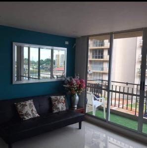 een woonkamer met een bank en een balkon bij Caranday, Las Palmas in Ricaurte