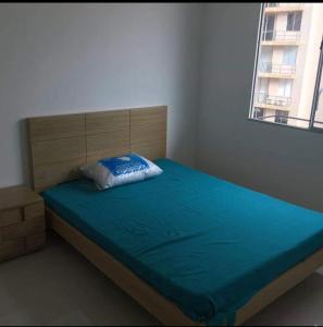 een slaapkamer met een bed met een blauwe deken erop bij Caranday, Las Palmas in Ricaurte