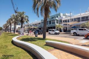 a city street with palm trees and a building at Apartment 303 Tauranga in Tauranga