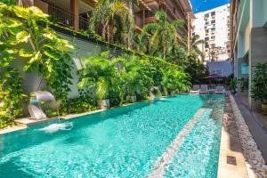 ein Swimmingpool mitten in einem Gebäude in der Unterkunft WOOVO Phuket Patong - by Swandor in Patong Beach